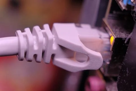 Close-up of a White Ethernet Connector Plugged into a Network Switch Foto stock