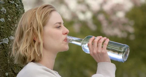Close up of white female drinking out of a glass bottle Stock Footage 107163580