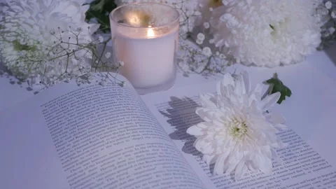 Close-up white flowers on an open book.burning candle. chrysanthemum. gypsophila Stock Footage 260417759