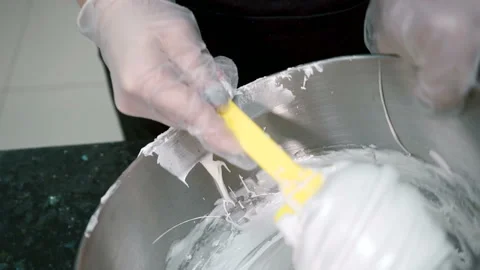Close up of white foam is being added to the dough in metal bowl. Stock Footage 86424283