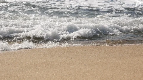 Close up of white foamy waves breaking on the sandy sea shore Stock Footage 103623085