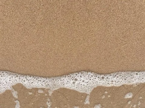 Close-up of white foamy waves on a sandy beach (2) Stock Photos
