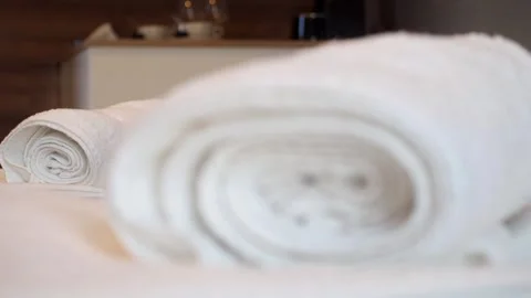 Close-up on a white fresh and clean folded towels on a hotel room bed Stock Footage 248529236