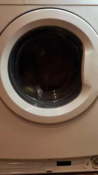 Close up of a white front loading washing machine door in a laundry room 스톡 사진