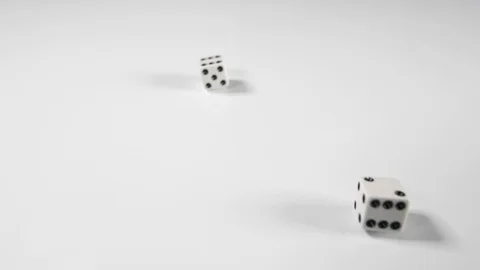 Close up of a white gamble double dice spinning onto a white surface background Stock Footage 89187575