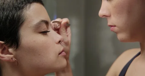 Close up White Girlfriends Plucking Eyebrows Together at Home Stock Footage 100569798