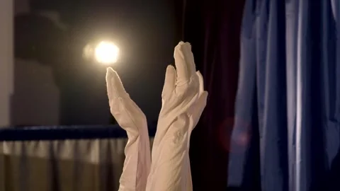 Close-up of white-gloved hands applauding on dark blue theater stage Stock Footage 340887460