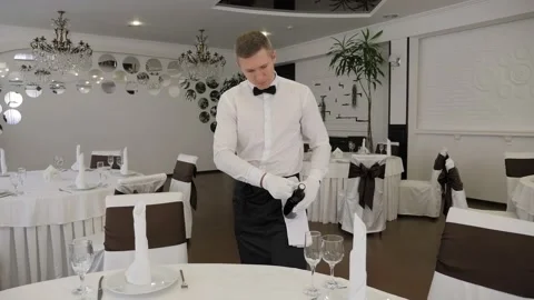 Close-up of a white-gloved waiter opening a bottle of red wine with a corkscrew. Stock Footage 168248558