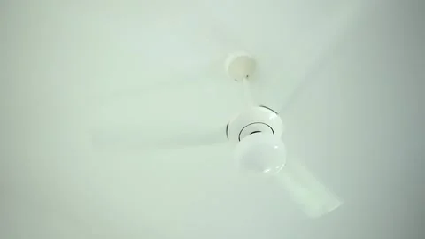 Close up white hanging ceiling fan with 3 blade and lamp spinning fast and Stock Footage 260732147