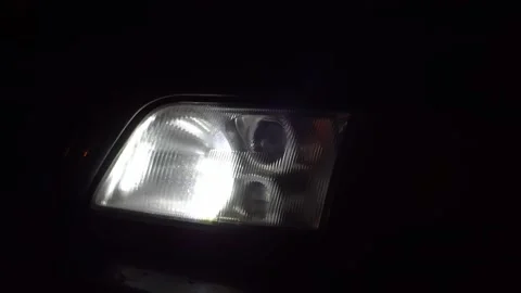 Close-up of white headlights on a car. running lights turn on at night. Vidéo 144080542