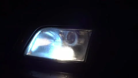 Close-up of white headlights on a car. running lights turn on at night. Vidéo 144080710