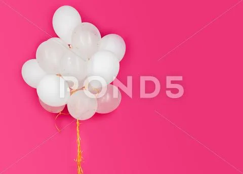 Close Up Of White Helium Balloons Over Pink