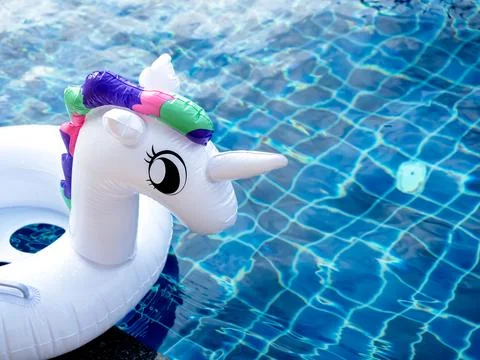Close up the white inflatable ring, cute unicorn doll in the outdoor swimmi.. Stock Photos