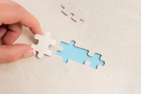 Close-Up White Jigsaw Pattern Puzzle Pieces To Be Connected With Missing Last Stock Photos