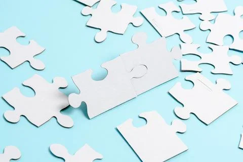 Close-Up White Jigsaw Pattern Puzzle Pieces To Be Connected With Missing Last Foto stock