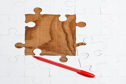 Close-Up White Jigsaw Pattern Puzzle Pieces To Be Connected With Missing Last Foto stock