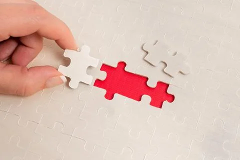 Close-Up White Jigsaw Pattern Puzzle Pieces To Be Connected With Missing Last Foto stock