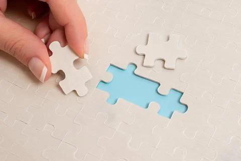 Close-Up White Jigsaw Pattern Puzzle Pieces To Be Connected With Missing Last Stock Photos