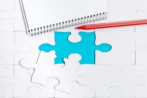 Close-Up White Jigsaw Pattern Puzzle Pieces To Be Connected With Missing Last Foto stock
