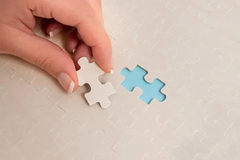 Close-Up White Jigsaw Pattern Puzzle Pieces To Be Connected With Missing Last Foto stock