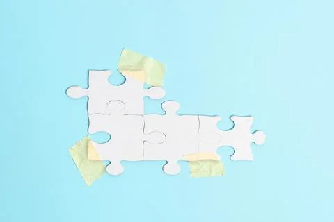 Close-Up White Jigsaw Pattern Puzzle Pieces To Be Connected With Missing Last Foto stock