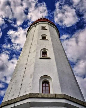  Close up of a white lighthouse with 4 windows on top of each other. Backgrou Stock Photos