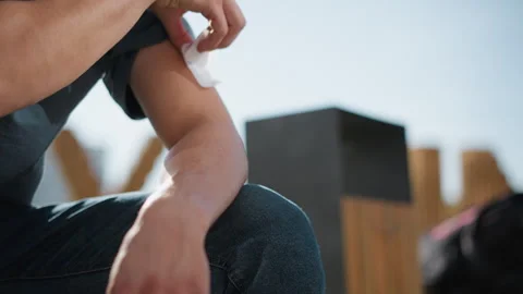 Close up white man applying nicotine patch on arm outdoors Stock Footage 307055373