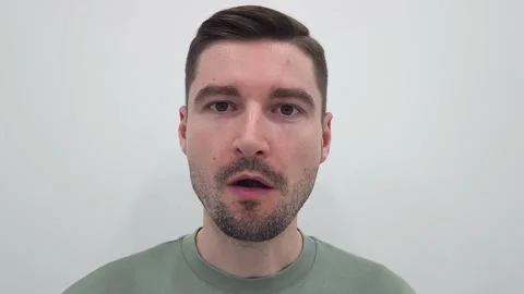 Close-up of a white man chewing against a plain white background. Stock Footage 284043683