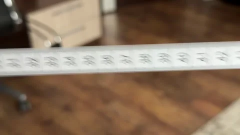 Close-up of a white measuring tape with centimeters unrolling and falling Stock Footage 321700051