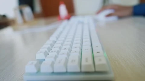 Close-up of a white mechanical keyboard on a desk video with blurred backgrou Stock Footage 318056575