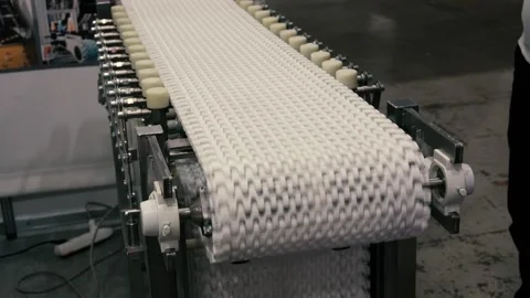 Close-up of a white modular conveyor belt in motion within an industrial setting Video stock 311506910