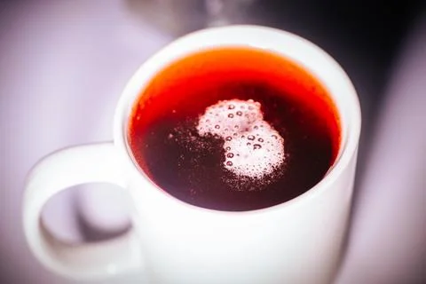 Close-up of a white mug filled with a red beer cherry drink. Foto stock