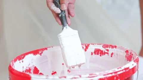 Close up of white paint dripping from a brush, process of preparing to paint Stock Footage 249283348