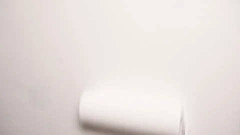 Close-up of a white paint roller gliding over the wall in motion blur. The Stock Footage 311898130