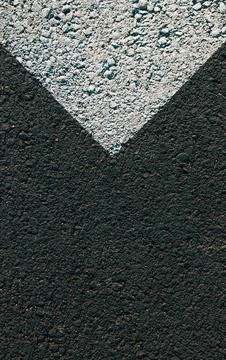 Close-up of a white painted road marking forming a downward pointing V shap.. Fotos Stock
