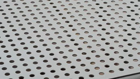 Close-up of a white perforated metal panel with round holes Stock Photos