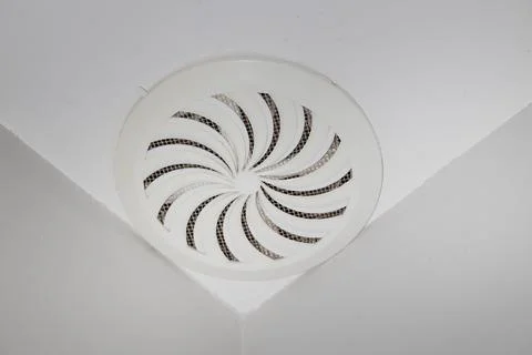 Close up of a white plastic round ventilation grille with spiral design Stock Photos