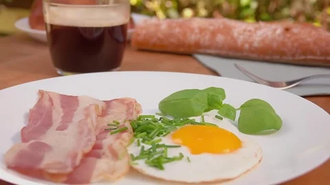 Close-up of the white plate with fried bacon and eggs Video stock 288528038