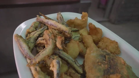Close-up of a white plate piled high with crispy fried seafood Vídeo Stock 330906158