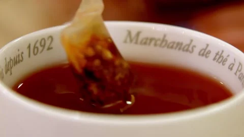 Close up of a white porcelain cup filled with hot tea and a string tag 库存影片 332545385