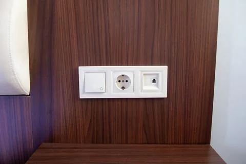 A close-up of white power socket, power outlet plug and light switch on a woo Stock Photos