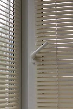 Close up of a white pvc frame window with venetian blinds slightly open Stock Photos