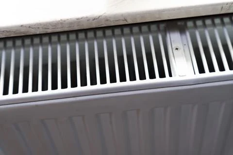 Close-up of a white radiator grill installed under a marble countertop, Stock Photos