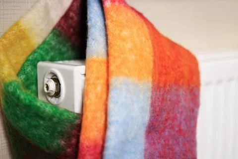 A close-up of a white radiator wrapped in a multi-colored scarf, symbolizin.. Foto stock
