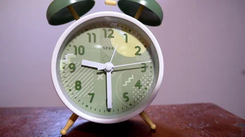 Close-Up of a White Retro Alarm Clock on a Wooden Table Stock Footage 338295913