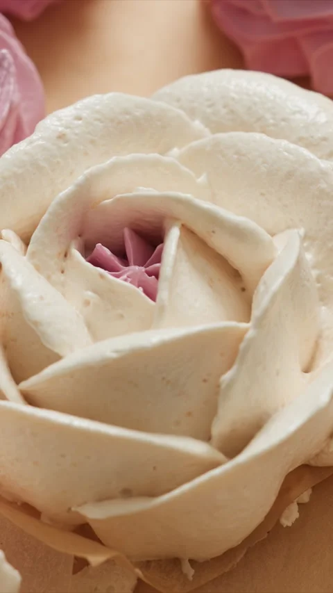 Close up of white rose shaped cream decoration with pink center detailing on Stock Footage 344419215