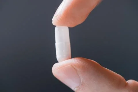 Close up. white round tablet in a human hand . Stock Photos
