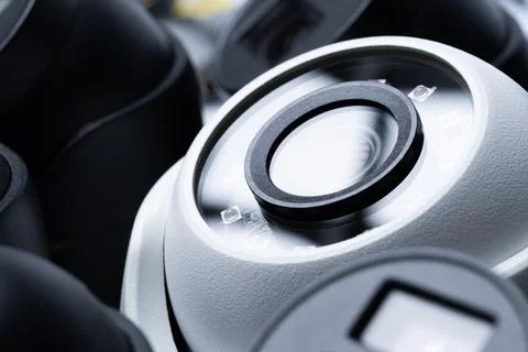 Close-up white security camera with black cameras nearby. Stock Photos