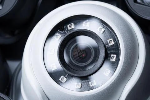 Close-up white security camera with black cameras nearby. Stock Photos