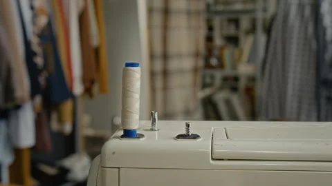 Close-up of Off-White Sewing Machine with Vertical White Thread Spool Stock Footage 328358627